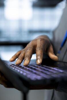 Programmer in data center facility typing on laptop keyboard, configuring rigs. Close up of IT specialist using notebook in server farm, verifying settings to maintain stable performance photo