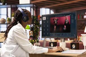 Woman in apartment using AI software turning text prompt into photos and listening music. Person in brick wall home loft wearing headphones uses text to image generative models on PC