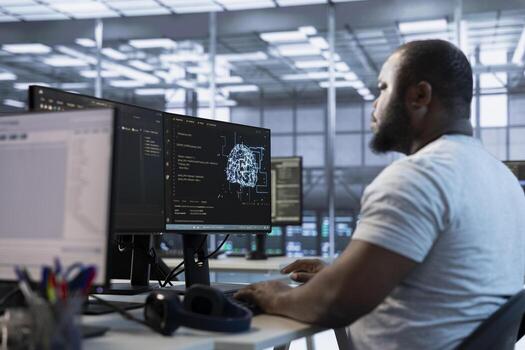 Admin working in server hub, sitting at computer desk, checking recovery plan, monitoring data center energy consumption across components, making sure sensors are functioning optimally photo