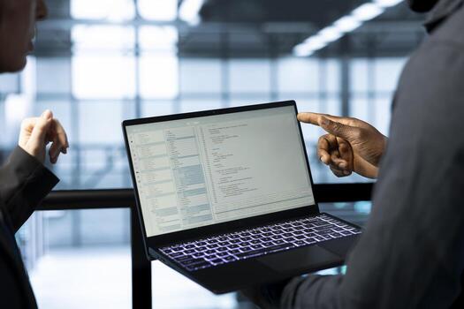 Software developers in data center using laptop, employing machine learning models. Close up of workers using notebook to fulfill infrastructure needs, allocating resources efficiently photo