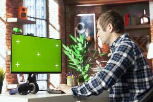 Worker at desk completing spreadsheets on mockup computer, entering numerical data into cells, calculating totals. Man analyzing figures on green screen PC, using spreadsheet software functions photo