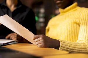 African american schoolgirl receiving personalized learning materials based on school curriculum, ensuring academic success through knowledge and research. Tutoring in a library. Close up. photo