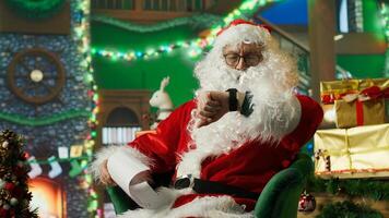 Person in Christmas costume alerted after dozing off and running late on delivering gifts to children. Santa Claus waking up after falling asleep on armchair while reading letters from kids, camera A photo