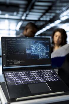 Focus on laptop used by teamworking data center computer scientists in blurry background using artificial intelligence neural networks to do computing processes, close up shot photo