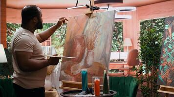 Artist applies watercolor paints on a canvas with a paintbrush, creating a stunning piece of fine art. Painter uses vibrant colors and dynamic brushstrokes effects as leisure activity. Camera B. photo