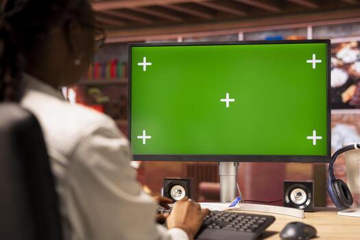Freelancer in apartment office using green screen PC display to work on job tasks. Close up shot of remote employee at home using chroma key computer monitor to do job online photo