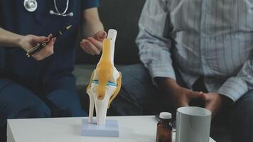 A doctor is holding a model of a knee video