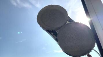 Robot vacuum cleaner washes windows with two gray microfiber attachments on a sunny day close up video