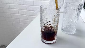 Two glasses with straws on a table next to a window video