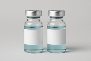 Pair of identical medical vials with silver caps and blank white labels filled with light blue liquid photo