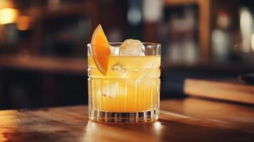 Refreshing orange cocktail with ice and garnish on wooden surface. photo