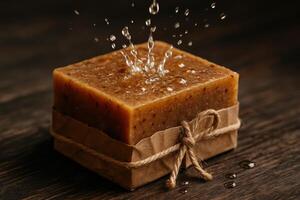 Natural handmade soap bar with water splashes on dark wooden surface photo