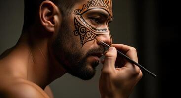 Man applying intricate tribal face paint design with a brush, close up profile view photo