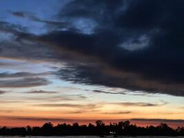Dramatic sky over dark horizon sunset clouds photo