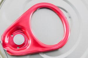 A red metal can with a metal ring on it photo