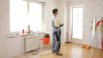 A man standing in a room with tools and a window video