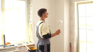 A man is painting a room with a roller video