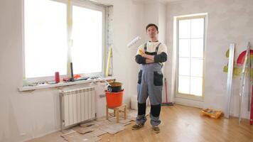 A man standing in front of a window with a paint brush video