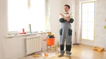 A man standing in a room with a bucket and a paint brush video