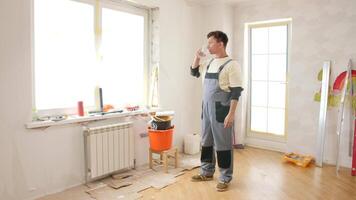 A man in overalls standing in a room with a ladder video