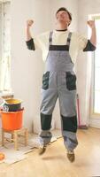 A man in overalls jumping in the air video