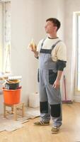 A man in overalls standing in a room with a bucket and a banana video