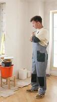 A man and woman standing in a room with a paint bucket video