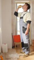 A man in overalls drinking water from a bottle video