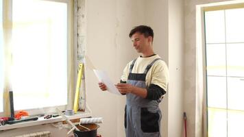 A man in overalls standing in front of a window video