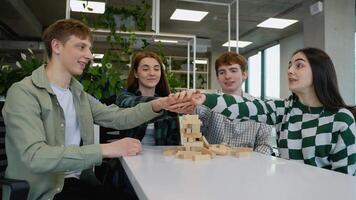 Teenagers friends playing jenga, stacking and balancing wooden blocks video