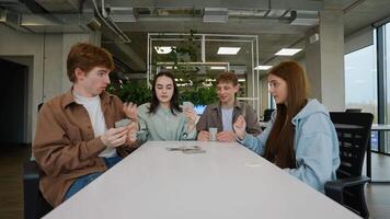 Students playing cards in modern office during break time video
