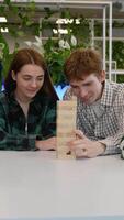 Students playing jenga, concentrated teenagers enjoying board game video