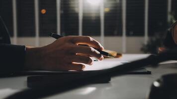 A person writing on a piece of paper at a desk video