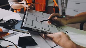 A man is working on a laptop while another person is holding a pencil video