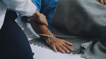 A doctor is holding an iv drip to a patient's hand video