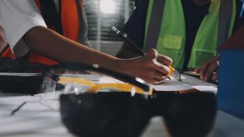 A man in a safety vest and glasses is writing on a piece of paper video