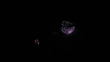 Colorful fireworks bursting over city skyline at night. Celebration atmosphere, festive lights, and urban backdrop video