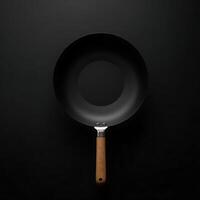 Wok with Wooden Handle on Dark Background Overhead Kitchen Still Life photo