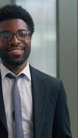 African American man business guy male businessman looking in window think gazing look at camera smiling happy portrait job ambition professional worker indoors smile work success ethnic entrepreneur video