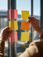 Office Workers Collaborate Through Divider Window, Exchanging Colorful Sticky Notes in a Bright Modern Workspace photo