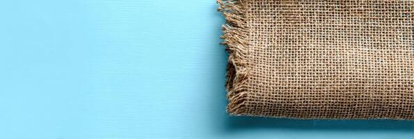 Eco-friendly Packaging Displayed on Burlap Cloth Against a Clean Sky-Blue Background Creates a Fresh and Sustainable Visual Appeal photo