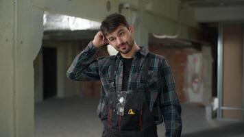 Caucasian man builder architect working on construction site building male industry worker rubbing head thoughtful pondering guy handyman foreman in uniform thinking technician electrician repairman video
