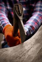 Close-Up Of A Man Lumberjack Chopping Wood With Axe. Focused on ax, trimmed frame without face. photo