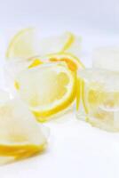 Close-up of glistening ice cubes and juicy orange slices on white background. Refreshing concept with copy space. photo