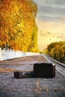 Two Suitcases On An Autumn Train Platform With Golden Trees At Sunset. photo