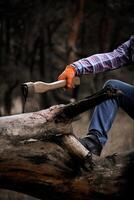Cropped view of Man Chopping Wood With Axe In Forest photo