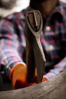 Focused on ax that stuck into wood. Close-Up Of Man Chopping Wood With Axe Outdoors. photo