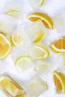 Top view of glistening ice cubes and juicy orange and lemon slices on white background. Refreshing concept. photo