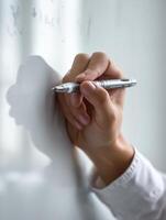 Teacher Demonstrating Writing Techniques on Whiteboard During Classroom Session in a Learning Environment photo
