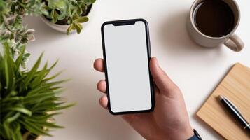 Texting on a Smartphone With Thumbs in a Minimalist Workspace Featuring Plants and Coffee photo